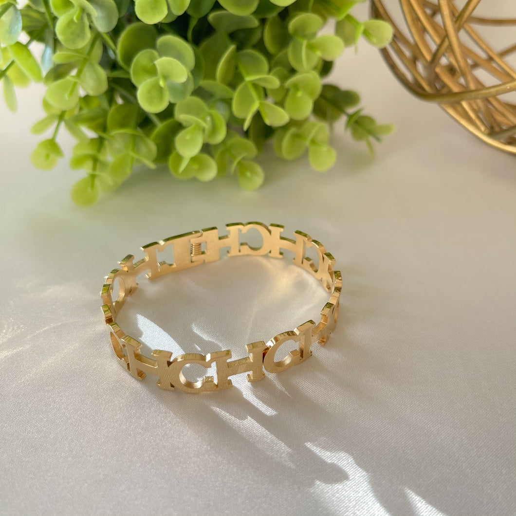 Brazalete y anillo CH de oro